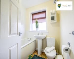 Baño blanco con lavabo y aseo en LOW RATE this season for 5 BR House with 2 Baths- Coventry Near Birmingham By Passionfruit Properties With free Netflix Wi-Fi by A45 - THL, en Coventry