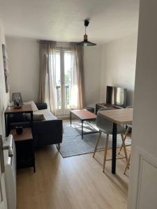 uma sala de estar com um sofá e uma mesa em Appartement de 25 m² à Blonville em Blonville-sur-Mer