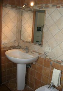 a bathroom with a sink and a toilet and a mirror at COLORI DEL MARE FAVIGNANA CENTRO in Favignana