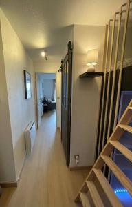 um corredor que leva a um quarto com um beliche em Appartement de 25 m² à Blonville em Blonville-sur-Mer