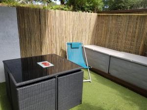 a blue chair sitting next to a table in a backyard at Studio avec mezzanine in Saint-Georges-de-Didonne