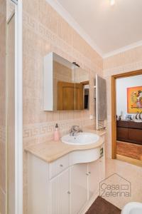 uma casa de banho com um lavatório e um espelho em Casa Zeferina - Zeferina Family em Leiria