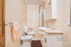 a white bathroom with a toilet and a sink at Casa Zeferina - Zeferina Family in Leiria