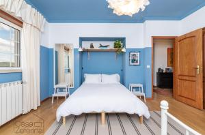 een blauwe slaapkamer met een bed en een blauwe muur bij Casa Zeferina - Zeferina Family in Leiria