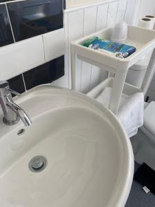 a bathroom with a white toilet and a sink at Stunning 3 bedroom property- Large Rooms in London