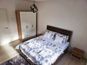 - une chambre avec un lit doté de draps et d'oreillers bleus et blancs dans l'établissement Apartman Platan, à Trebinje