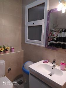 y baño con lavabo, espejo y aseo. en Amwaj North coast chalet in 1st floor families only, en El Alamein