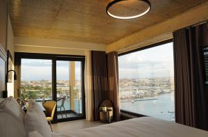 a bedroom with a bed and a large window at The Londoner Hotel Sliema in Sliema
