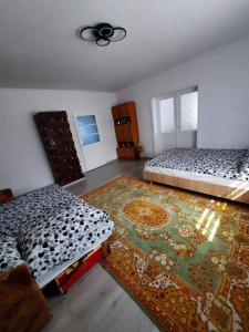 um quarto com duas camas e um tapete num quarto em Anikó kulcsosház em Corund