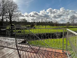 a fence on a deck with a view of a field at Villa im Alten Land Hamburg - für große Gruppen in Hamburg