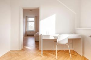 een wit bureau in een witte kamer met een stoel bij Villa im Alten Land Hamburg - für große Gruppen in Hamburg