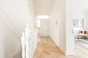 um corredor branco com escadas brancas e um sofá branco em Villa im Alten Land Hamburg - für große Gruppen em Hamburgo