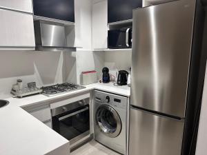 a kitchen with a stainless steel refrigerator and a dishwasher at Departamento con Amenities in Pinamar