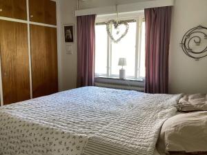 Un dormitorio con una cama grande y una ventana en Holiday home NYHAMNSLÄGE, en Nyhamnsläge