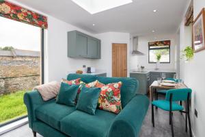 a living room with a green couch and a table at Ruecroft, Penruddock in Penruddock