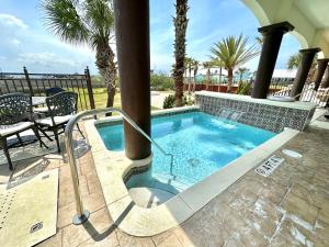 a swimming pool in a resort with palm trees at Bliss By The Sea in St. Augustine