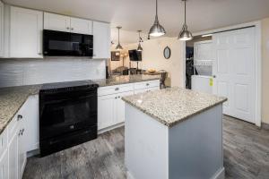 una cocina con armarios blancos y un aparato negro en Nautilus 2411 Gulf View 2 Bedroom 4th Floor Free Beach Service en Fort Walton Beach