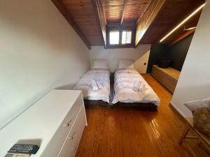 a small bedroom with two beds in a attic at Caja De Anthea in Artemida