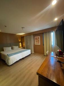 a hotel room with a bed and a television at Flat 246 king em hotel na avenida Ibirapuera - SP in Sao Paulo