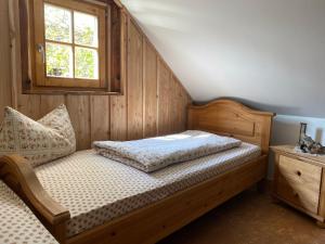 1 dormitorio con cama de madera y ventana en Walnußhof, en Schmogrow