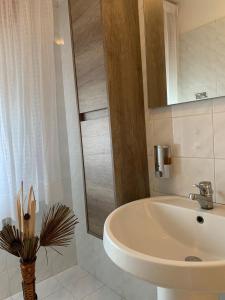 een witte badkamer met een wastafel en een spiegel bij Pamir Casa Vacanze Appartamento in Trapani