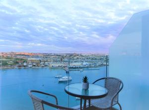 a table and chairs on a balcony with a view of a harbor at The Londoner Hotel Sliema in Sliema