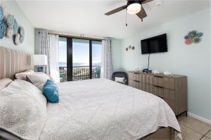 a bedroom with a bed and a tv and a window at Nautilus 2408 Gulf View 2 Bedroom 4th Floor Free Beach Service in Fort Walton Beach