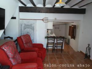 a living room with red chairs and a table at Casa del Puente in Nerpio