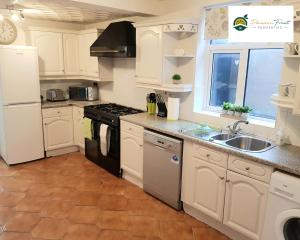 a kitchen with white cabinets and a sink at 3 Bedroom 2 Bath House By Passionfruitproperties Near Coventry City Centre - Free Wi-fi, Pool Table And Garden - MAC in Coventry