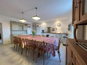 eine Küche und ein Esszimmer mit einem Tisch und Stühlen in der Unterkunft Gîte de 12 personnes au cœur d'un domaine viticole in Gruissan