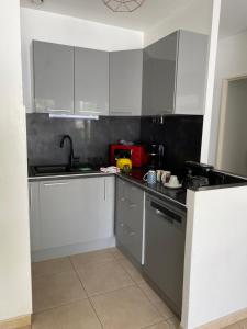 Jolie Villa avec jacuzzi Hôpitaux facultés في مونبلييه: مطبخ بخزائن بيضاء ومغسلة