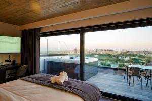 a bedroom with a large window with a view at The Londoner Hotel Sliema in Sliema