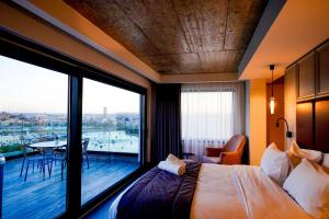 a hotel room with a bed and a large window at The Londoner Hotel Sliema in Sliema