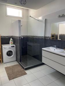 a bathroom with a shower and a washing machine at Jolie Villa avec jacuzzi Hôpitaux facultés in Montpellier