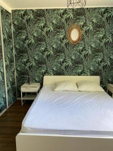 ein Schlafzimmer mit einem Bett mit einer grünen Wand in der Unterkunft Jolie Villa avec jacuzzi Hôpitaux facultés in Montpellier