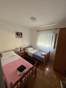 a bedroom with two beds and a window at Apartments Marina in Posedarje
