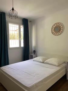 Jolie Villa avec jacuzzi Hôpitaux facultés في مونبلييه: غرفة نوم مع سرير أبيض ومرآة على الحائط +3 صور