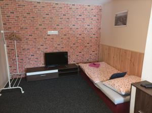 a room with two beds and a brick wall at Apartmány Litvínov centrum in Litvínov