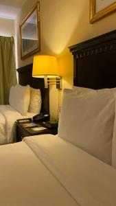 una habitación de hotel con 2 camas y una lámpara en una mesa en Hotel Las Palmas Inn, en Punto Fijo