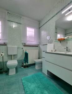 uma casa de banho com um WC, um lavatório e uma banheira em Apartma Vista montana em Kobarid