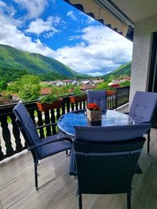 una mesa y sillas en un balcón con vistas en Apartma Vista montana, en Kobarid
