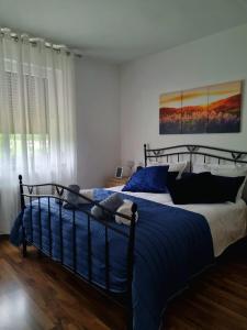 um quarto com uma cama grande e lençóis azuis em Apartma Vista montana em Kobarid