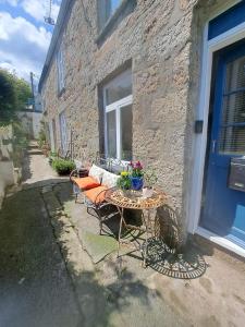 a table and a bench in front of a building at Telagraph cottage in Penzance
