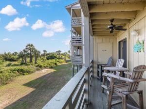 een veranda met 2 stoelen en een plafondventilator bij Lighthouse Point 15A in Tybee Island