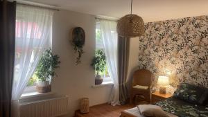 a living room with a bed and two windows at Agro na Wapniarni in Białla