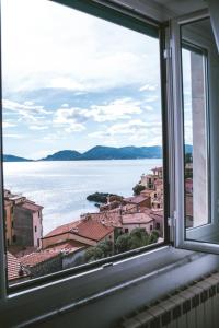 a window with a view of the water and buildings at Albergo delle Ondine in Tellaro