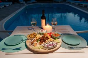 uma mesa com um prato de comida e uma garrafa de vinho em Casa Roa em Dunavăţu de Jos