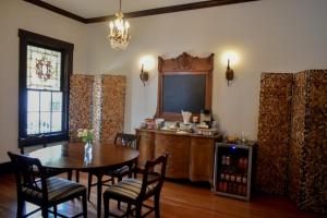 Sparrow Grove Manor في مونرو: غرفة طعام مع طاولة وكراسي وتلفزيون