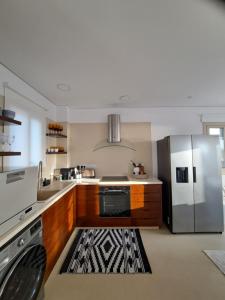 cocina con nevera de acero inoxidable y alfombra en Nireas Villa, en Pafos