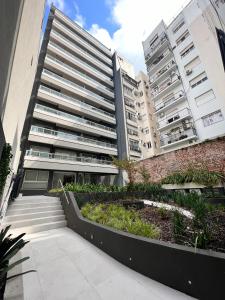 um edifício de apartamentos com um jardim em frente em Barrancas Quality Apartments em Buenos Aires